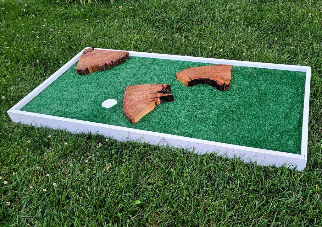 Miniature golf board with wooden holes on a grassy background